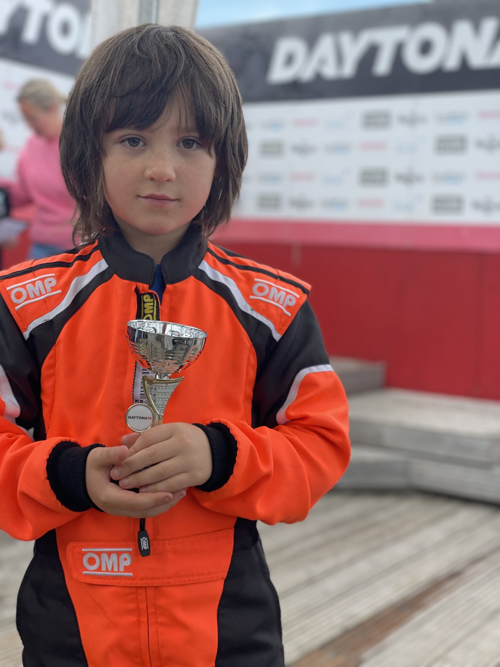 A younger Felix in his orange suit holding a silver trophy